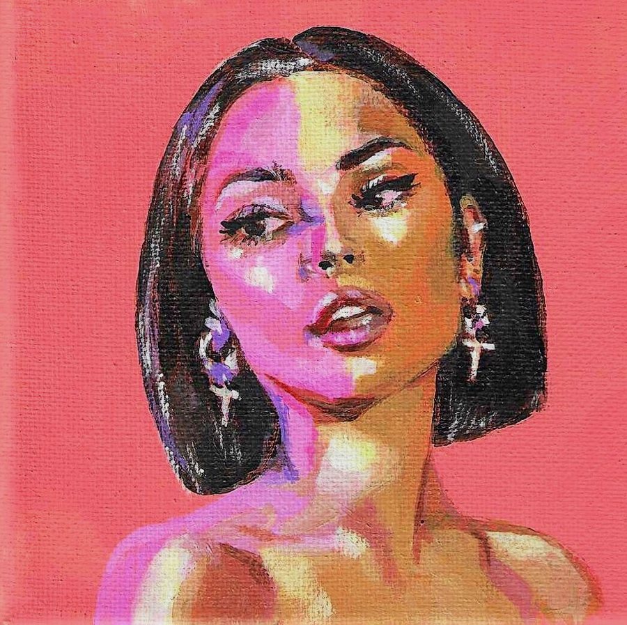 Portrait of a woman with a dark bob and cross earrings on coral pink