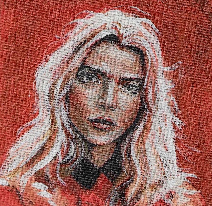 Portrait of a woman with long pale hair on a red background