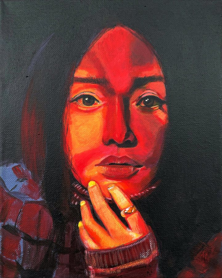 Portrait of a woman lit in red, hand at her chin