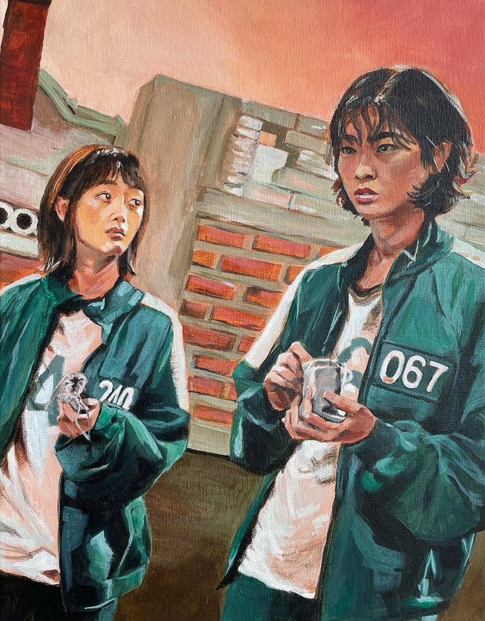 Two women in green tracksuits in front of a brick wall